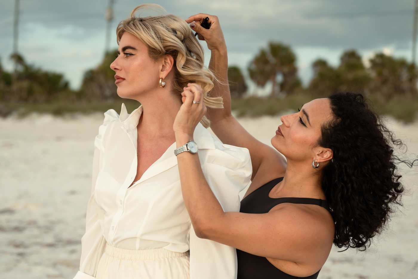 Miah styling a model's hair on set at the beach
